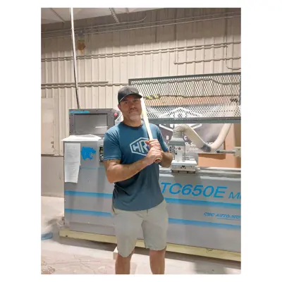 Man standing in front of machinery with baseball bat