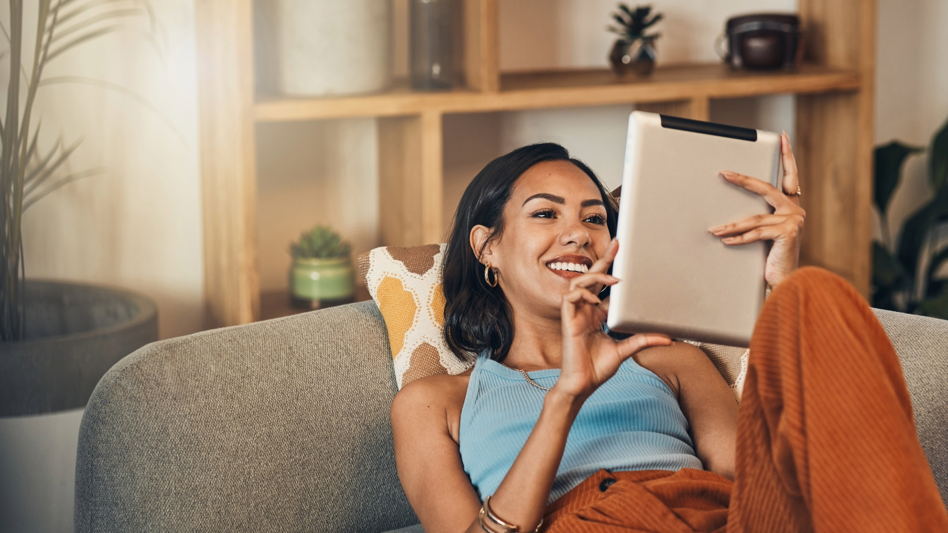 Woman on couch reading on a tablet
