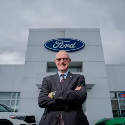 Man standing in front of a ford sign