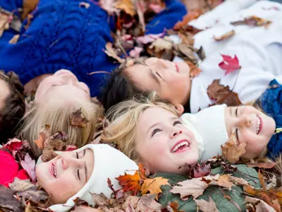 Group of kids laying in the leaves