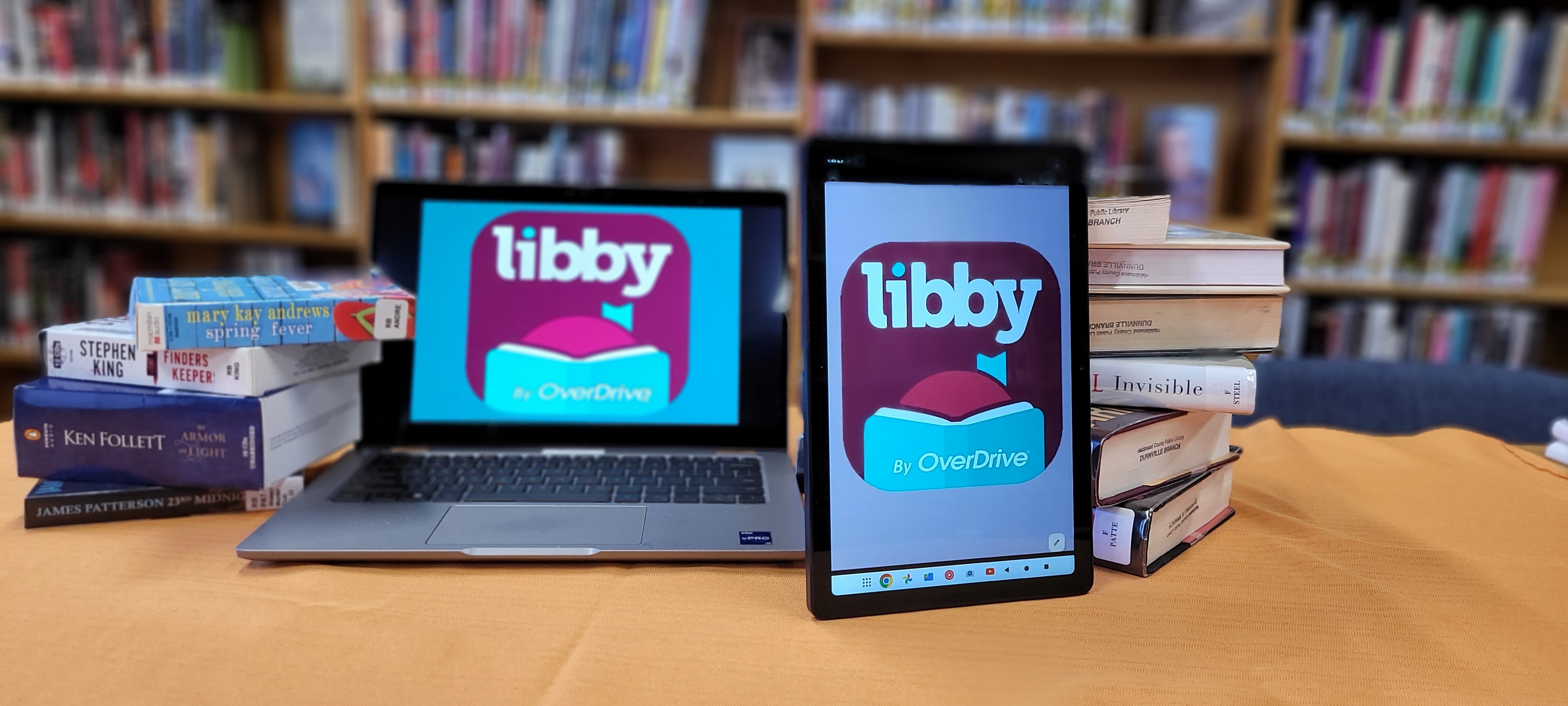 laptop and table on table with books and recorded books 