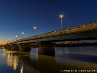 2020 2nd Place Photo - Bridge crossing the Grand River in the evening light with a blue cast, taken by Bob Thomson