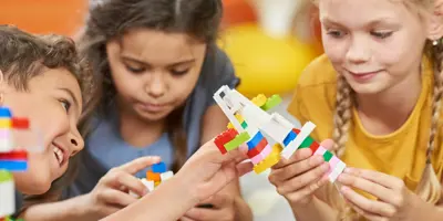 Three children playing with LEGO