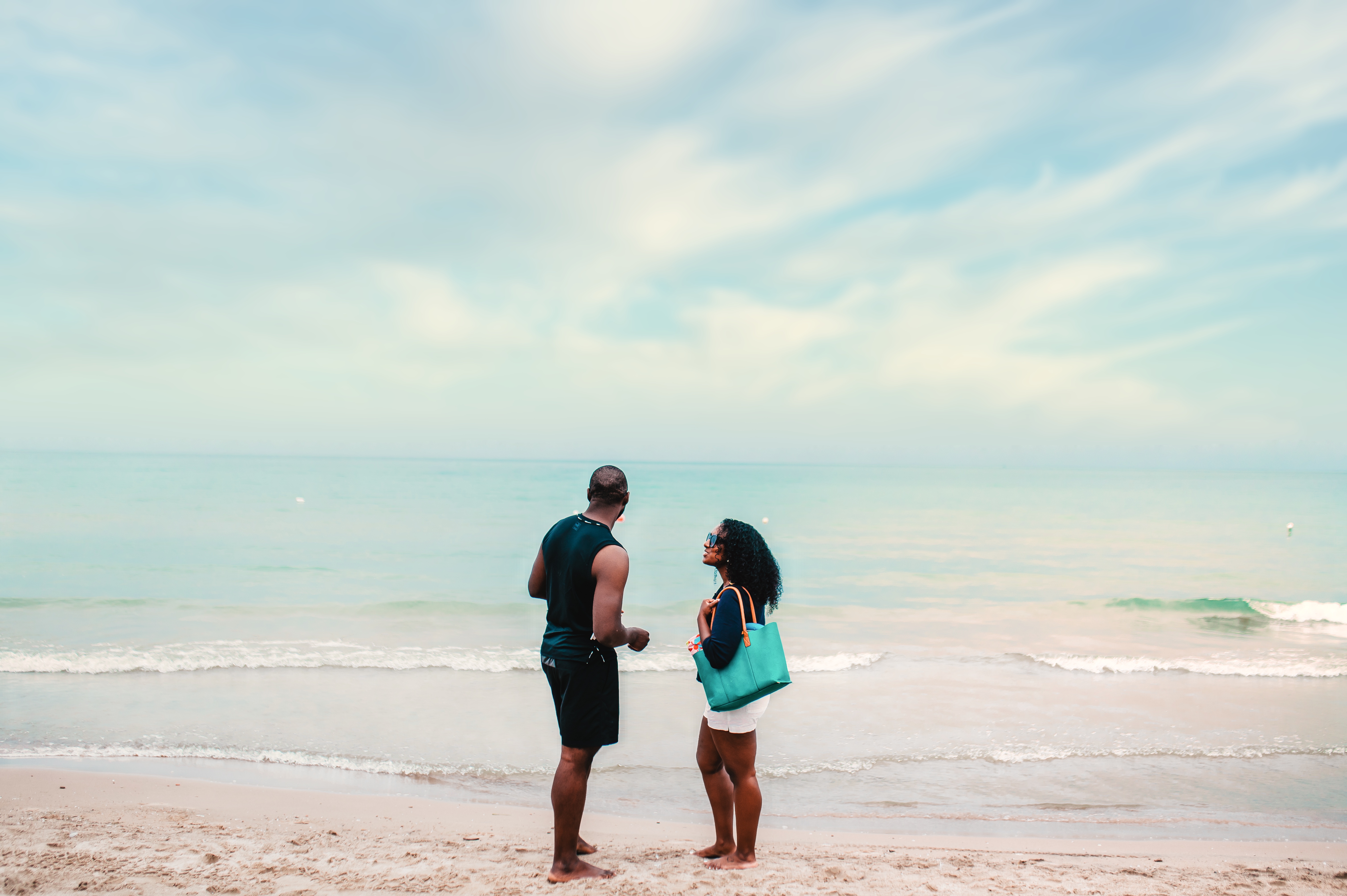 A couple look out across Lake Erie on a sandy beach
