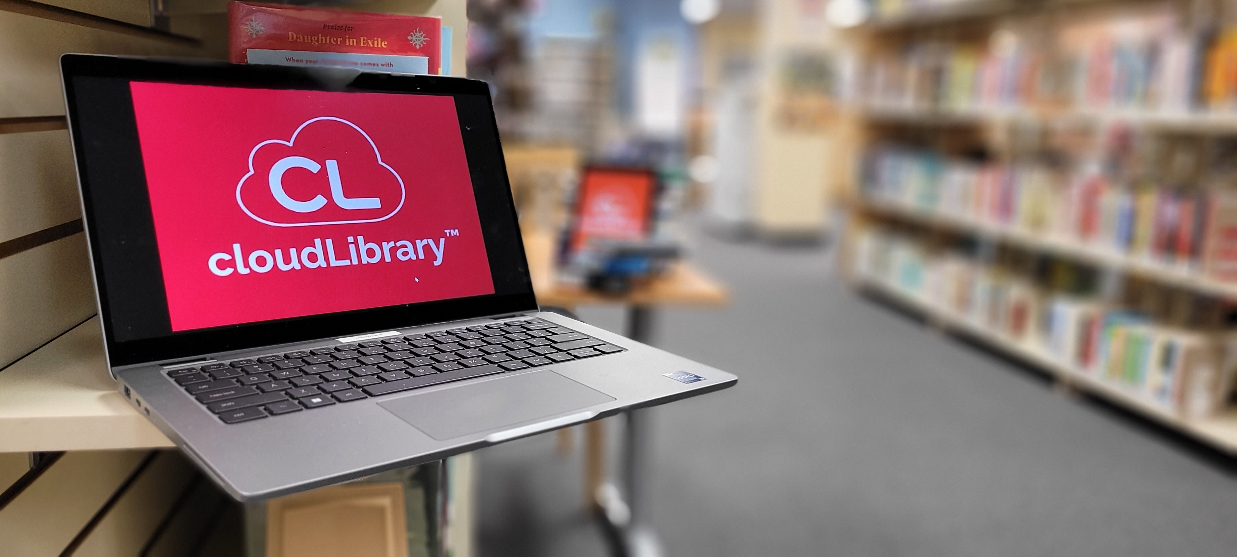 Laptop with CloudLibrary logo on screen on bookshelf