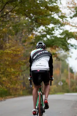 A single cyclist travels down a fall road